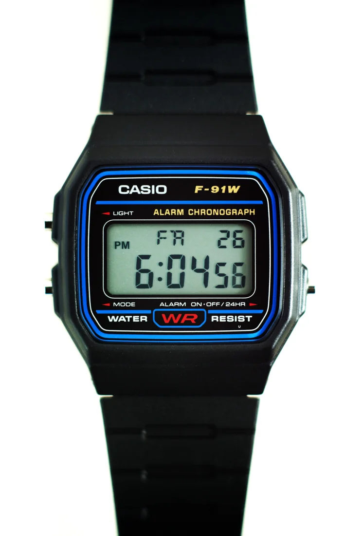 Black Casio F-91W-1 digital watch with blue face border, photographed in 2013