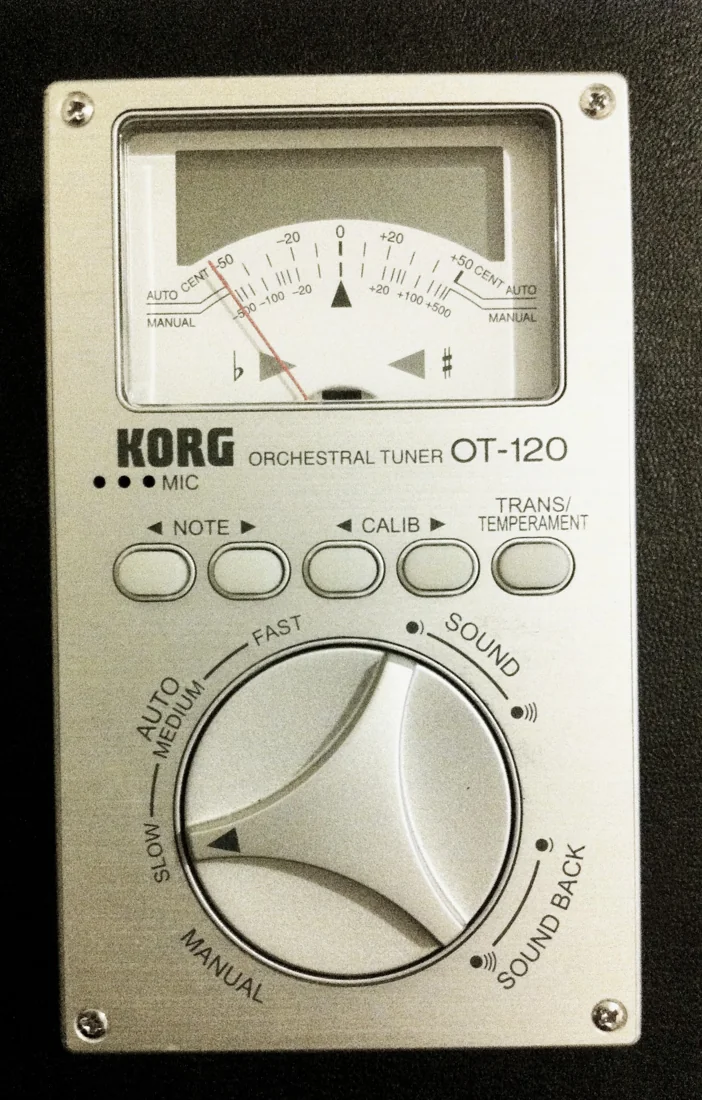 KORG OT-120 silver orchestral tuner with model marking, needle meter and mode dial visible