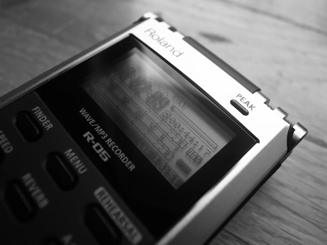 Original monochrome detail photograph of a Roland R-05 recorder showing the model label, display and controls
