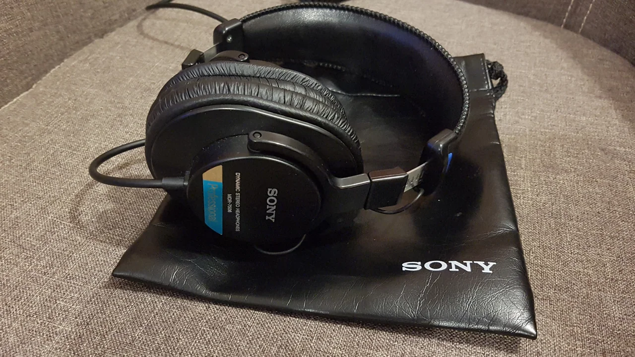 Black Sony MDR-7506 wired headphones on their Sony pouch, with model labels visible