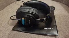 Black Sony MDR-7506 wired headphones on their Sony pouch, with model labels visible